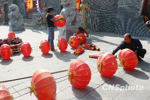 8月31日，河南省開(kāi)封市天波楊府門(mén)口，工作人員在準(zhǔn)備懸掛大紅燈籠。隨著“十一”國(guó)慶節(jié)和“十一”旅游黃金周的臨近，古城開(kāi)封的公園景點(diǎn)已早早開(kāi)始備戰(zhàn)，營(yíng)造喜慶祥和的旅游環(huán)境，迎接八方客人。 中新社發(fā) 李俊生 攝
