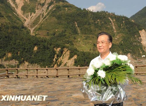 溫家寶總理十分關(guān)注災(zāi)后重建進(jìn)展情況。在國慶節(jié)和中秋佳節(jié)即將來臨之際，他第8次踏上了一直牽掛的這塊土地。在9月24日至26日的三天時間里，他奔波穿行于地震重災(zāi)區(qū)的城鄉(xiāng)間，為節(jié)省時間，吃飯盡量安排在火車上；連續(xù)兩個晚上主持召開會議，就災(zāi)后恢復(fù)重建的一系列重大問題進(jìn)行研究部署。這是9月24日，溫家寶在青川縣紅光鄉(xiāng)東河口村地震遺址祭奠臺獻(xiàn)花。新華社記者黃敬文攝