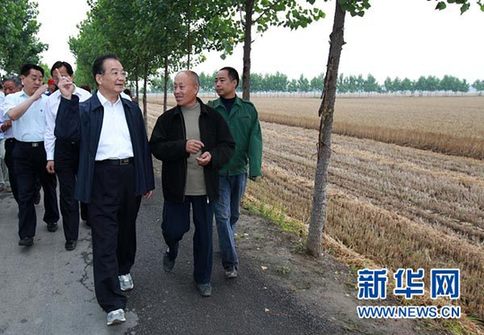 這是6月9日，溫家寶在長葛市石象鄉(xiāng)坡李王村的田間小路上與坡李王村支部書記李福成邊走邊聊。新華社記者龐興雷攝