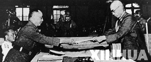 日本中國派遣軍總司令官岡村寧次在對華投降書上簽字，并向中方交出他的隨身佩刀，以表示侵華日軍正式向中國繳械投降。這是何應(yīng)欽(左)在南京代表中國政府接受侵華日軍總司令岡村寧次的投降書。新華社發(fā)
