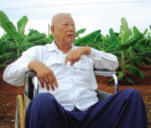 陳光保在自己的農(nóng)場(chǎng)里，他身后就是一片香蕉林(中青報(bào)蔣昕捷供圖)
