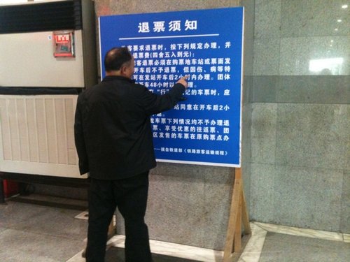 昨日，上海站，一位老人在認真研究退票新規(guī)。 李淑平 圖