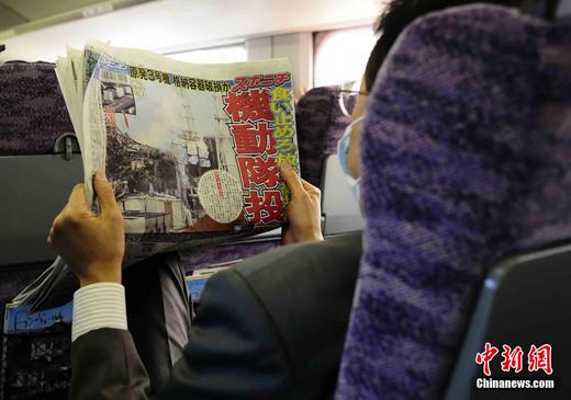 3月17日下午，在一列前往東京的新干線列車上，一名日本人在閱讀關(guān)于福島核電站三號(hào)機(jī)組最新狀況的報(bào)道。中新社發(fā) 侯宇 攝