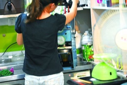 昨日，沙坪壩區(qū)一飲料店，店員在用添加劑勾兌果汁