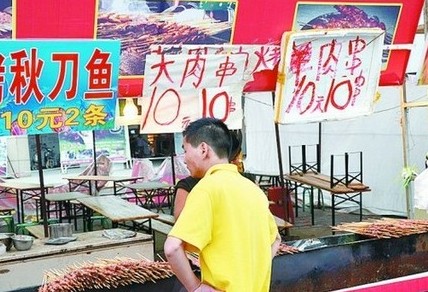 被查后，美食街上的'羊肉串'的'羊'字被涂抹了。