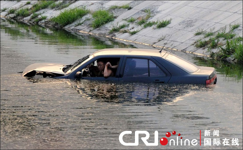 車(chē)沖入河中，依稀可見(jiàn)車(chē)中兩名男子正在打斗。