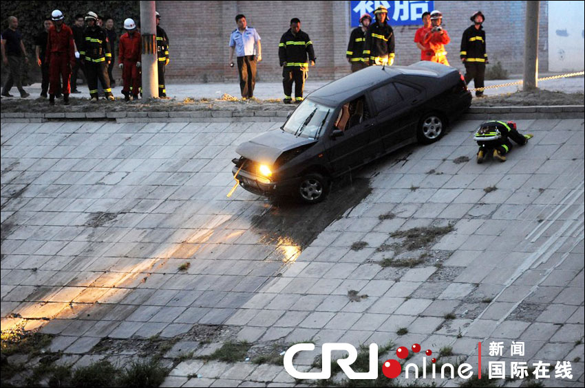 2012年6月17日下午，北京四元橋下方的西壩河輔路上，一輛轎車失控墜河中。消防員將轎車拖上岸。