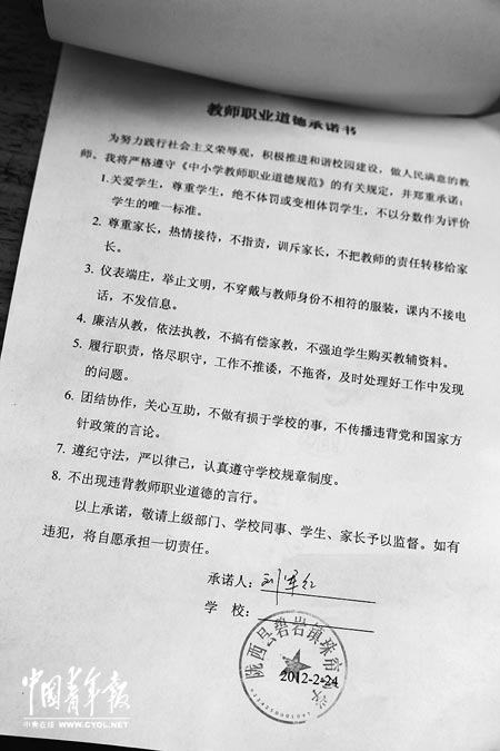 劉軍紅簽字的教師職業(yè)道德承諾書。本報(bào)記者 張鵬攝