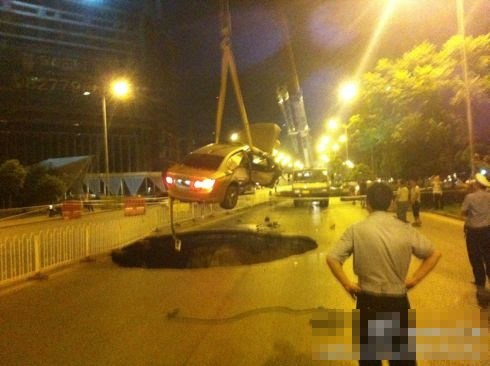 吊車將墜入塌陷坑的汽車吊出。圖/末代小王爺