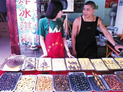 青島劈柴院驚現蛇尖上的小吃 眼鏡蛇被切段火上烤