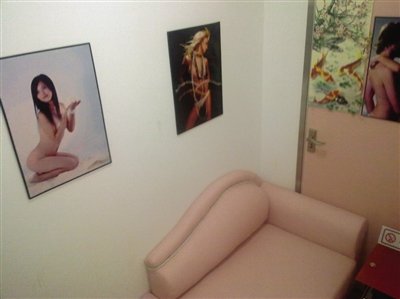 取精室內(nèi)，有一個粉色沙發(fā)，墻壁四周掛著女體畫