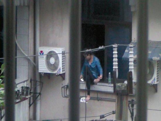 美女坐窗臺兩個多小時，不時拿起手機看幾眼，難道是要跳樓自殺？