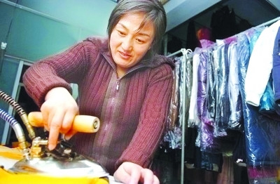 資料圖：鄒春蘭在自己洗衣店內(nèi)工作。圖片來(lái)源 揚(yáng)子晚報(bào)