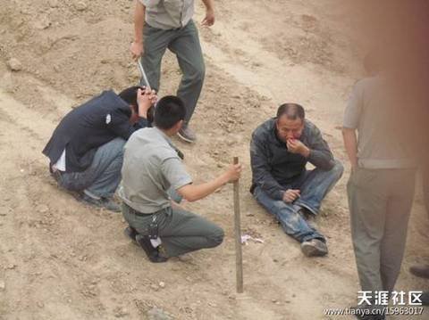 陜AWK707的西安城管執(zhí)法車和6名穿制服的城管，手持棍棒，在郊外毆打兩名倒地男子。 