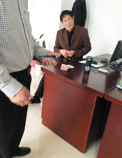 10月29日，獻(xiàn)縣國稅局稽查局辦公室內(nèi)，一名企業(yè)主交了兩萬元現(xiàn)金在桌上。新京報記者 孟祥超 攝