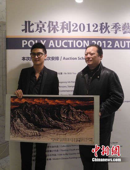 田亮與畫家洪潮合影，兩人展示《夢縈釣魚島》縮小版。
