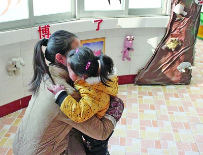 江都商貿(mào)幼兒園一位老師在擁抱該園的孩子。因?yàn)樯婕笆召M(fèi)，作為該園精品教育的一個(gè)項(xiàng)目，老師的擁抱行為也被質(zhì)疑。 董鑫 攝