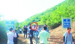 被困女子（圈中）獲救后從山嶺入口處豎有“軍事禁區(qū)”的標牌旁通過。