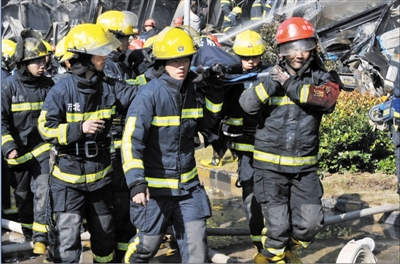 消防官兵將受傷的同事抬出。陳福 攝
