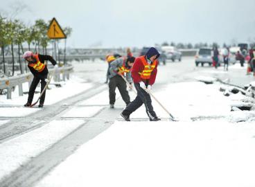 工作人員清理高速路上的積雪。 張磊攝