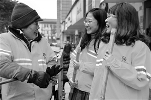 1月8日，22歲的王雪菁（右）和23歲的陶晨露（中）陪著她們的環(huán)衛(wèi)工人師傅鄧桂鸞聊天 新華社發(fā)