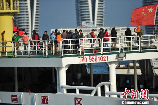 圖為24名“驢友”的“導(dǎo)游”被邊防的工作人員帶下船接受調(diào)查。 駱云飛 攝