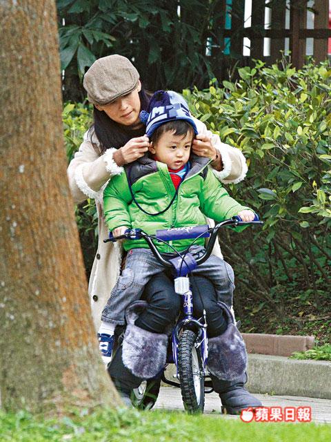 張柏芝抱quintus坐踩單車(chē)，又細(xì)心幫他整理冷帽