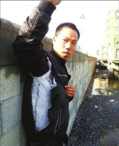 陳連弟向記者展示被撕壞的衣服。視頻截圖