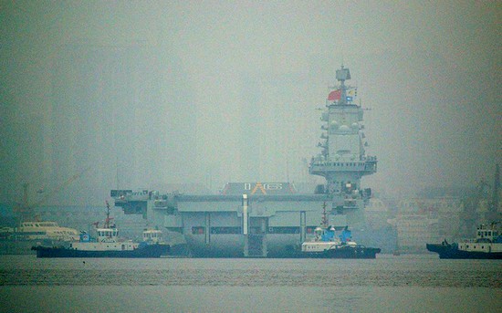 資料圖：大連港口大霧彌漫，中國首艘航母“遼寧艦”徐徐離開港口。
