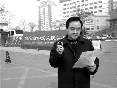 焦占軍在法院門口拿著決定書，無語站立。京華時報記者孫思婭攝