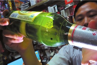 這瓶未開封的燕京啤酒內(nèi)有一顆黑色懸浮物。京華時報記者 徐曉帆 攝