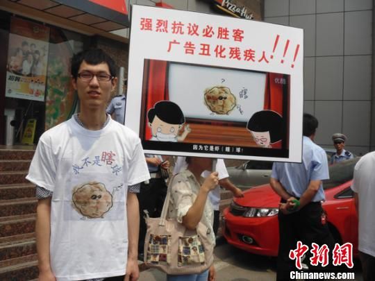 6月5日，視障人士在鄭州一必勝客門前舉牌抗議蝦球廣告歧視。 門杰丹 攝